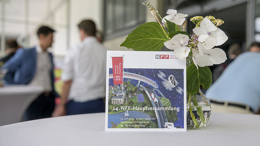 14. NFF-hauptversammlung:Einladungskarte neben einer Tischdecke auf einem Stehtisch