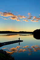 Ein Angler steht auf einem Steg an einem schwedischen See. 