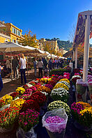 Ein belebter Marktplatz mit einer Vielzahl von bunten Blumen in der Auslage.
