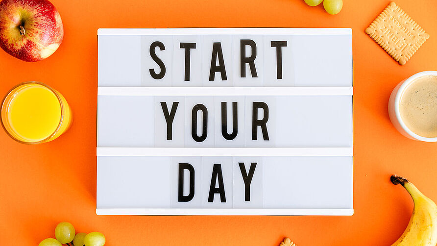 Lightbox auf orangem Hintergrund mit der Aufschrift "Start your Day"