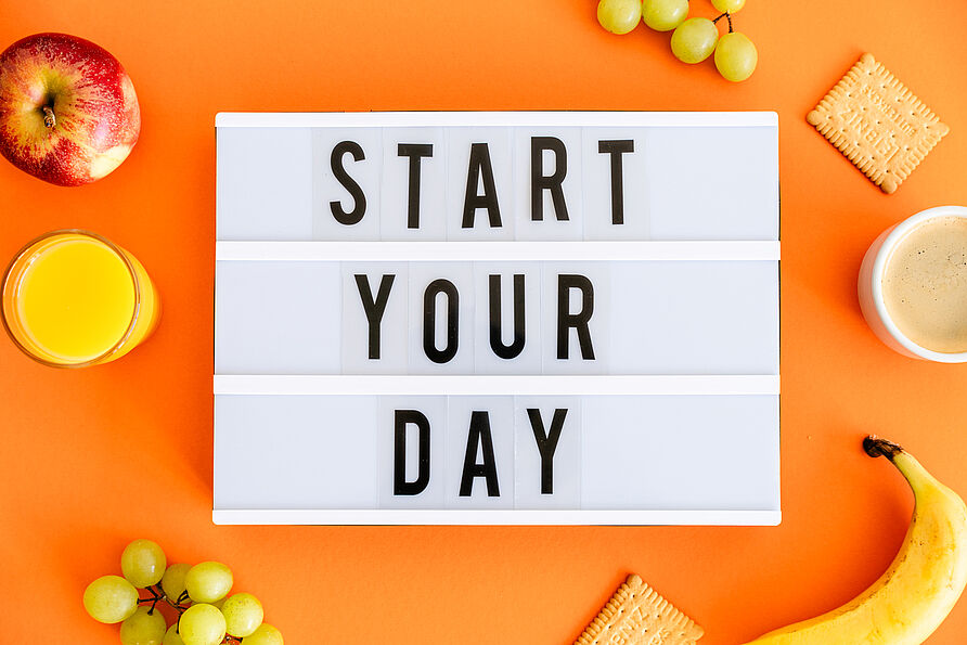 Lightbox auf orangem Hintergrund mit der Aufschrift "Start your Day"