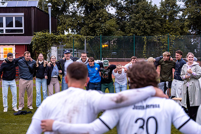 Zwei Fußballspieler und Fans