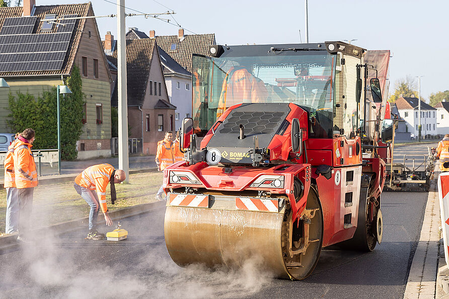 Nachdem die Walze den Asphalt geglättet hat, wird die Verdichtung und die Schichtdicke untersucht.