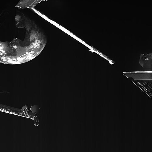 Selfie des BepiColombo-Satelliten mit dem Magnetometerausleger und der Erde im Hintergrund