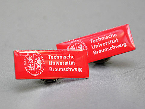Zwei Ansteckpins mit Logo der TU Braunschweig
