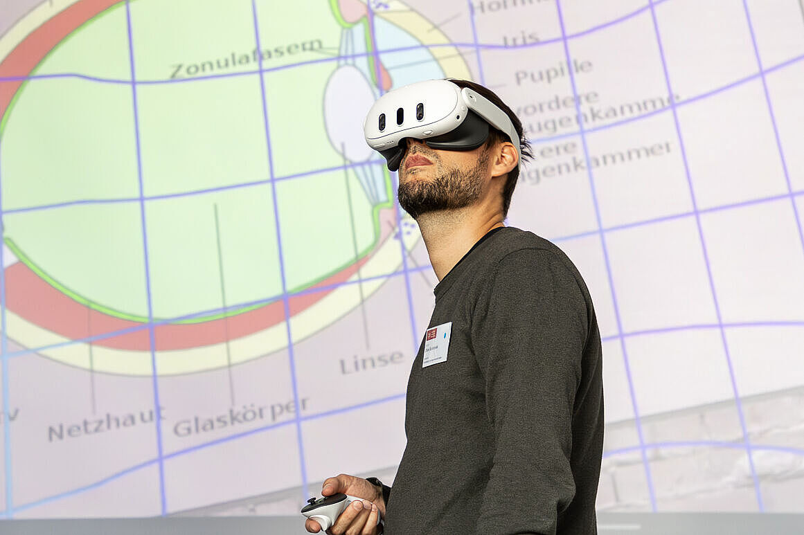 Ein Mann mit einer VR-Brille vor der schematischen Darstellung eines Auges
