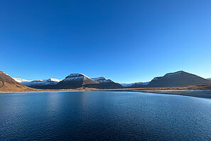 Blick auf eine Bucht in den Westfjorden Islands bei Sonnenschein.