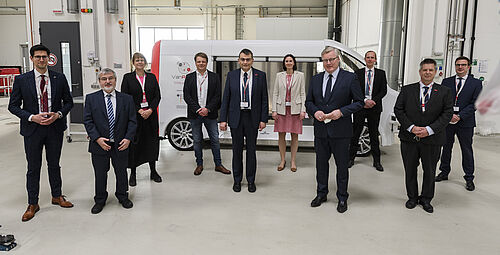 Delegation um Dr. Althusmann im NFF-Technikum. Im Hintergrund das NFF-Forschungsfahrzeug PLUTO. 