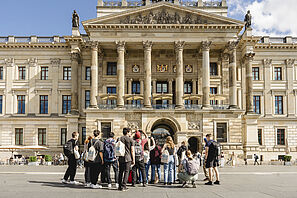 A group of students during a guided tour of the city in front of the castle in Braunschweig.