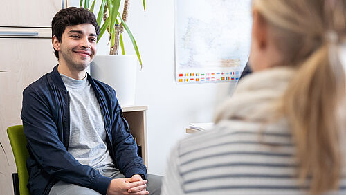 Ein Student sitzt in einer Beratungssituation.