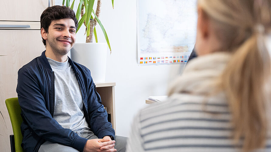 Ein Student sitzt in einer Beratungssituation.