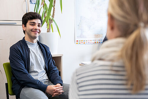 Ein Student sitzt in einer Beratungssituation.