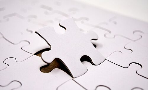 Titelbild, auf dem ein weißes Puzzlestück in ein ebenfalls weißes Puzzle eingesetzt wird. 