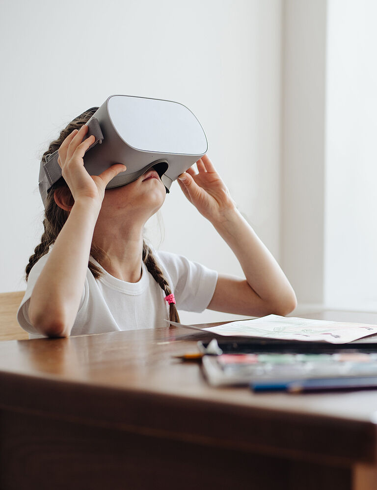 Kid girl using virtual reality glasses at home
