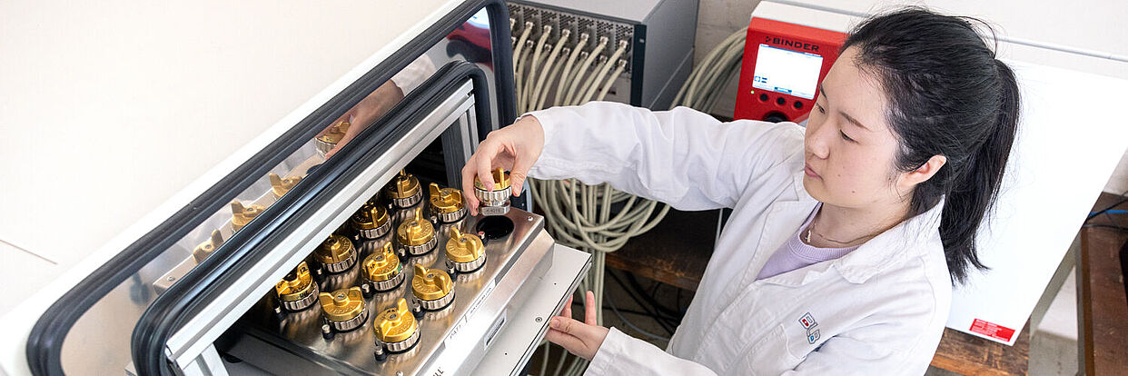 Yajie Wang (WiMi) beim Einsetzen von Batterie-Testzellen in den Zyklisierer (im Klimaschrank) 