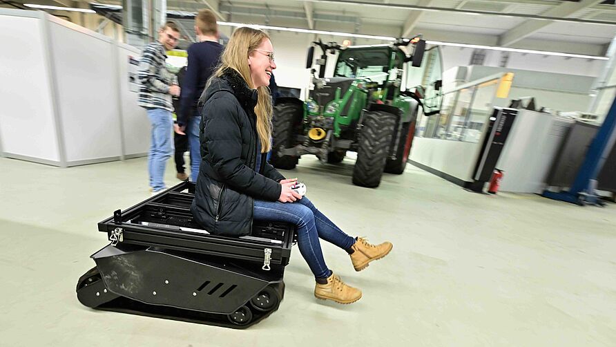 Infoabend für Studierende der Fahrzeugtechnik am NFF am 28.01.2026: junge Frau fährt auf einem Exponat im Technikum