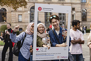 Students look through the Instagram photo frame and take a photo.