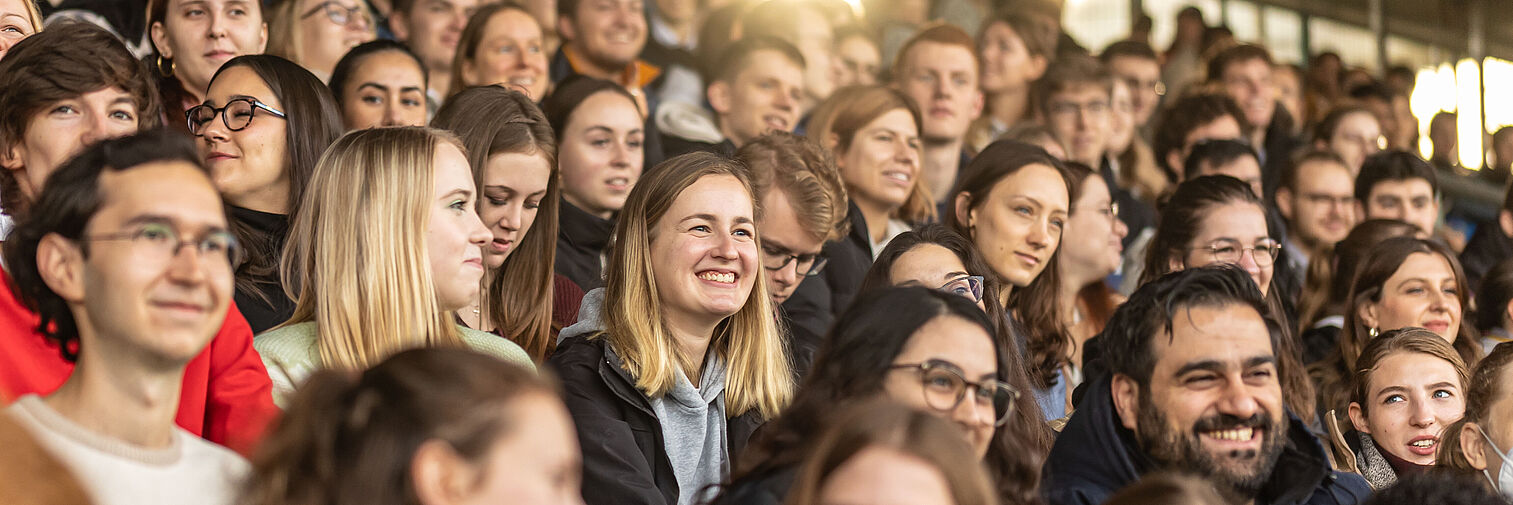 Studierende der TU Braunschweig sitzen auf der Tribüne des Braunschweiger Stadions 