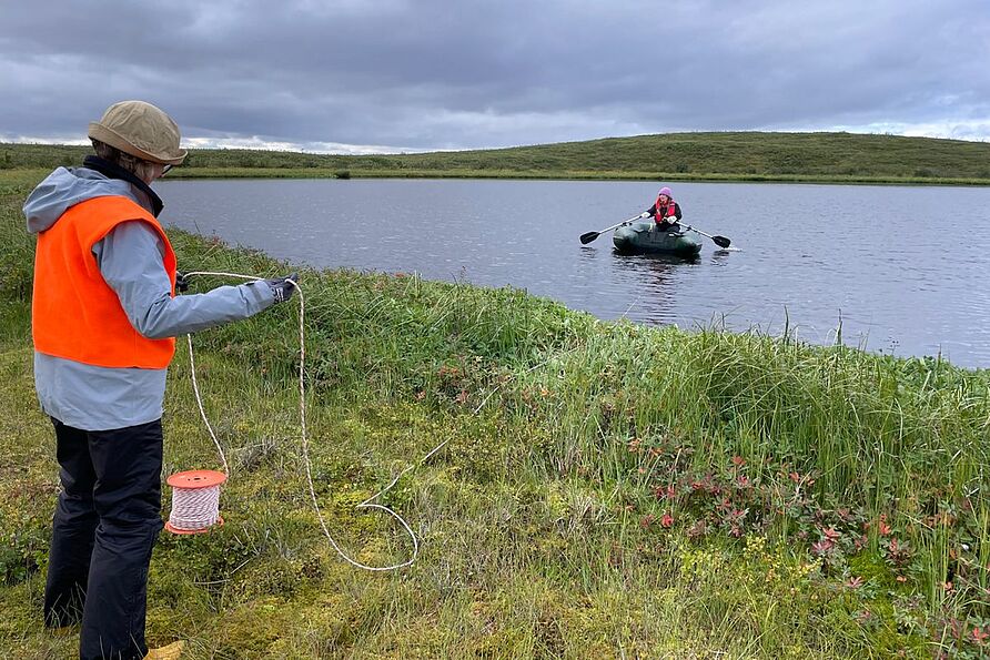 Professorin Antje Schwalb und Emma Cameron sammeln Sediment- und Wasserproben aus einem kleinen See in der Nähe eines Bohrschlammsumpfes. 