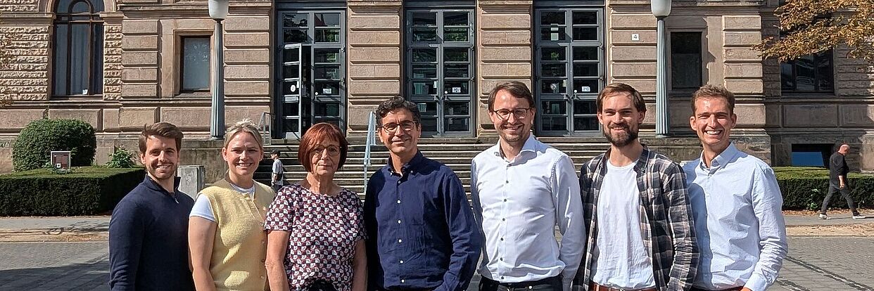 Zu sehen ist das Team des IPTP vor dem Altgebäude der TU Braunschweig 