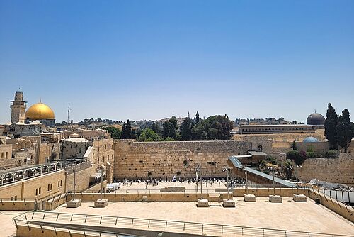 Die Klagemauer (in der Mitte) in Jerusalem ist der letzte Überrest des Jerusalemer Tempels, der 70 n. Chr. von den Römern zerstört wurde und die wichtigste Glaubensstätte der Juden. Dahinter befindet sich der Tempelberg mit dem Felsendom (goldene Kuppel) sowie die al-Aqsa-Moschee (graue Kuppel), zwei der wichtigsten muslimischen Stätten.
