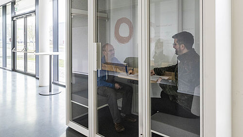 Zwei Menschen sitzen in einer NFF-Silent-Box