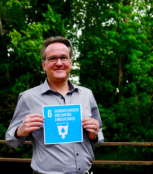 Prof. Dr.-Ing. Thomas Dockhorn hält die Karte zum 6. SDG.