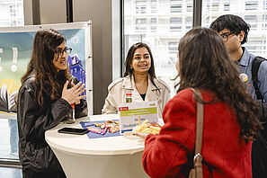 Studierende unterhalten sich während des Kick Offs der Welcome Week mit den Berater*innen an Infotischen.