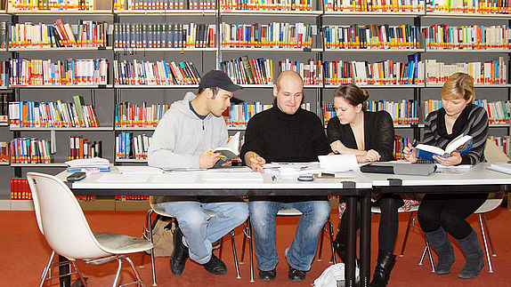 Studierende an einem Tisch in der Bibliothek