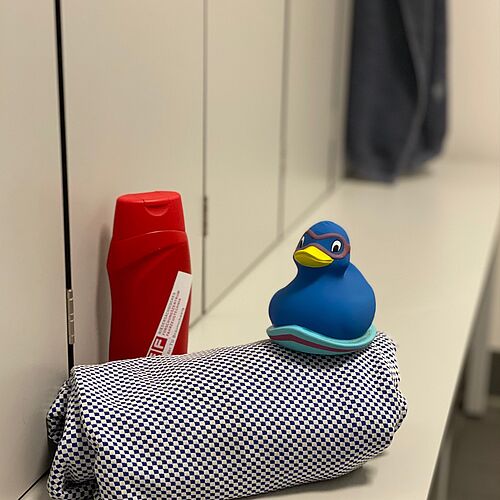 Geheime Orte im NFF: Duschen. Blaue Ente auf Handtuch mit Duschbad.