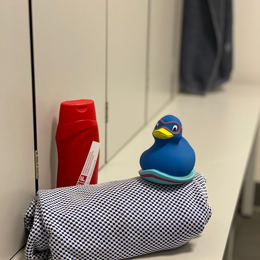 Geheime Orte im NFF: Duschen. Blaue Ente auf Handtuch mit Duschbad.