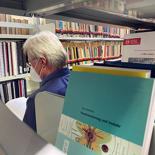 Dr. Wolfgang bartsch in der Bibliothek beim Lesen eines Buches.