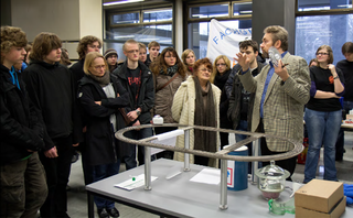 Besucher beim Schülerinfotag vor einem Experiment