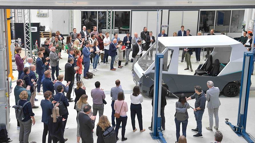 Gäste im NFF-Technikum sehen den RollOut des Versuchsfahrzeugs RAION während der Tagung am 2. Juni 2023 in Braunschweig.