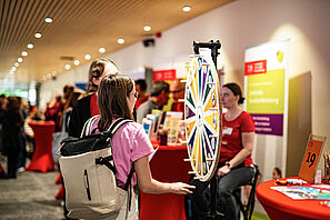 Eine Studieninteressierte dreht an einem Glücksrad