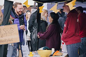 Studierende besuchen einen Stand auf dem Universitätsplatz
