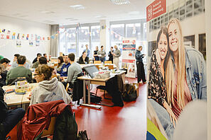 A fully occupied seminar with students chatting at tables.