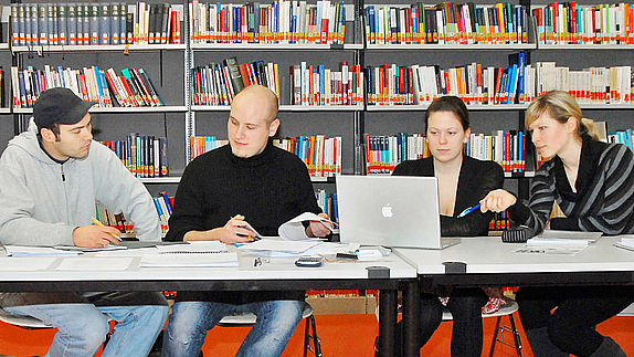 Studierende an einem Tisch in der Bibliothek
