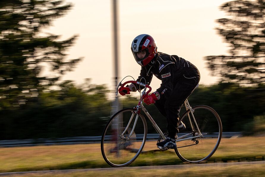 Frau mit Rennanzug auf Rennfahrrad