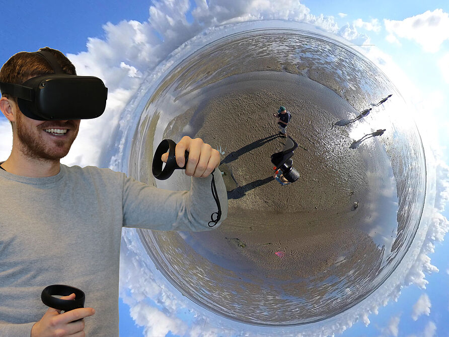 Bild einer Person mit VR-Brille im Wattenmeer
