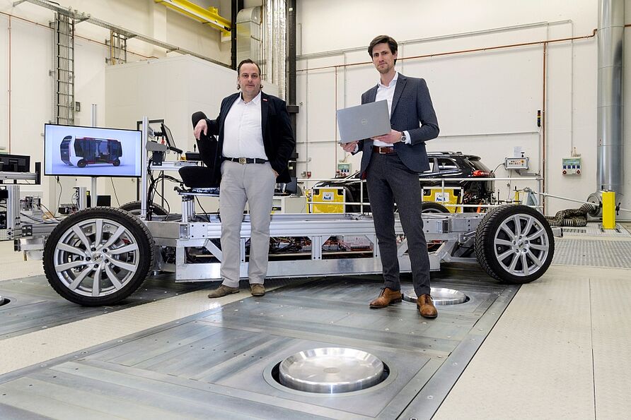 Prof. Henze (links) udn Adrian Sonka (rechts) vor einem autonomen Fahrzeug-Modul im NFF-Technikum.
